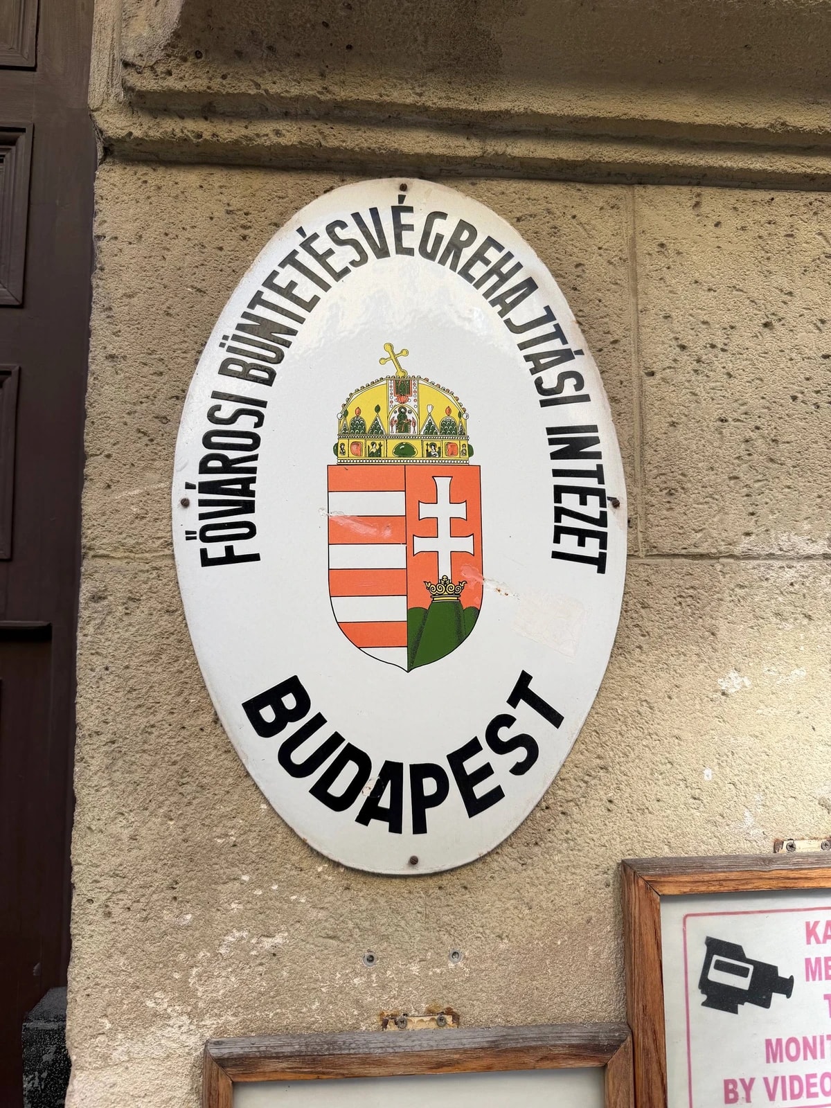 Plaque émaillée aux armes de la Hongrie signalant un établissement pénitentiaire à Budapest.